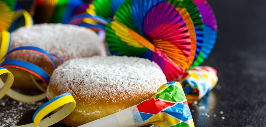 Pfannkuchen (Berliner) mit Puderzucker und Partydekoration